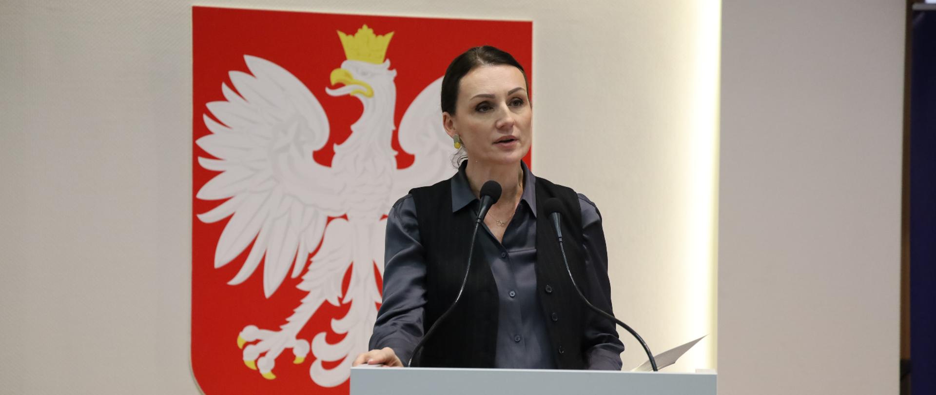 kobieta (wojewoda) przemawia, za nią godło Polski