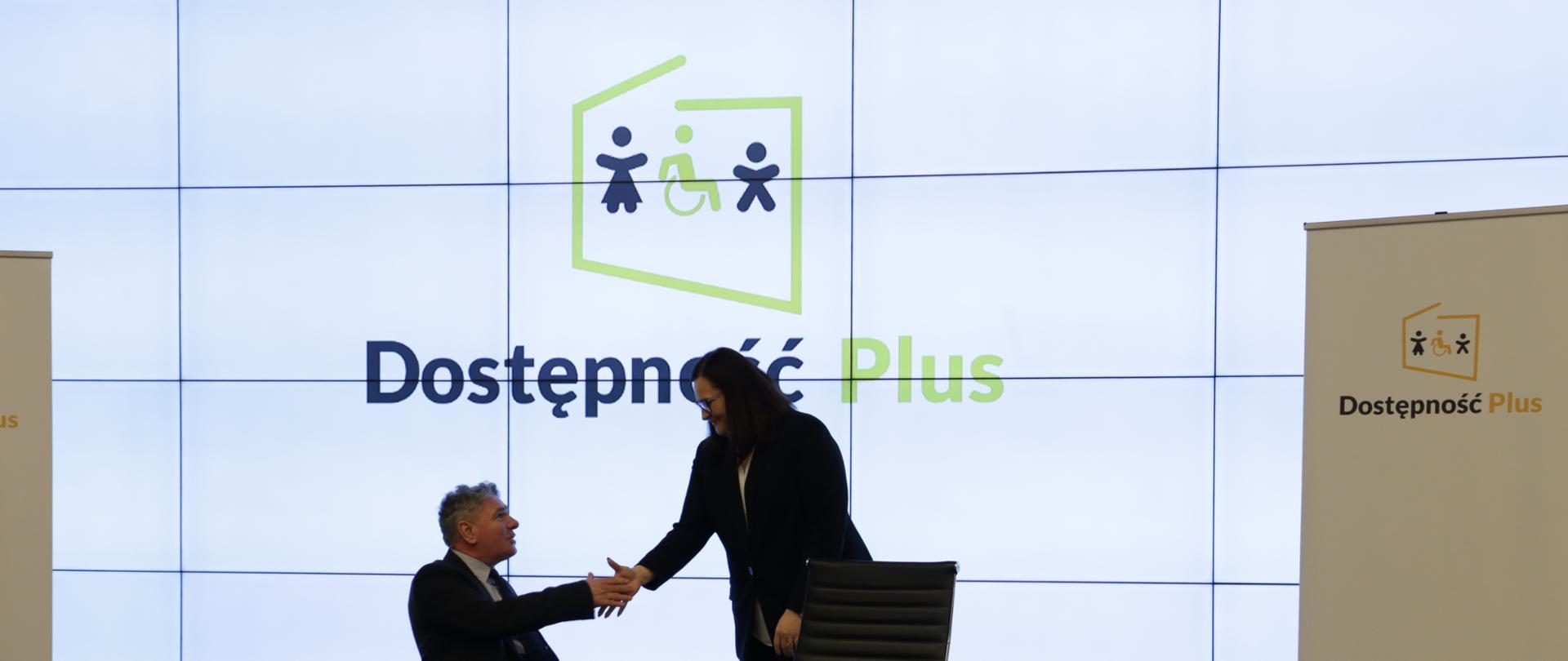 Wiceminister inwestycji i rozwoju Małgorzata Jarosińska-Jedynak podaje rękę panu na wózku inwalidzkim