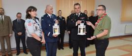 Na zdjęciu harcerze przekazują strażakowi i policjantowi światełko pokoju. 