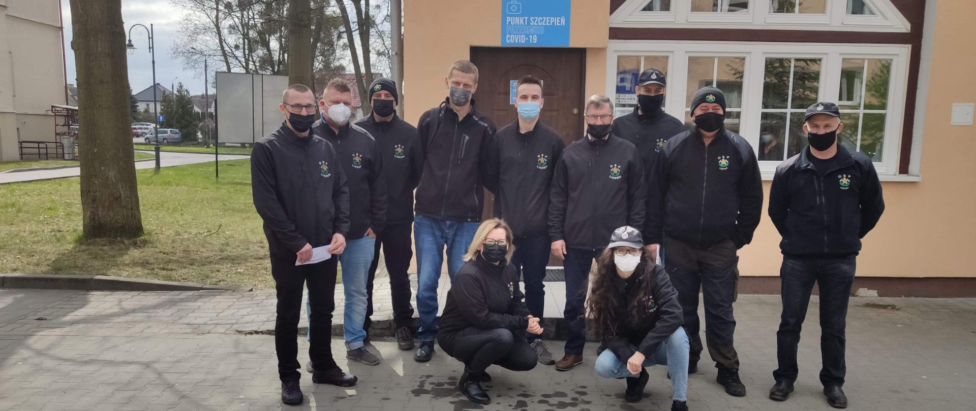 Zdjęcie przedstawia dziewięciu druhów Ochotniczej Straży Pożarnej w Lisewie oraz dwie
druhny z tej jednostki przed punktem szczepień w szpitalu w Chełmnie. Wszyscy ubrani w
bluzy polarowe OSP pozują do grupowego zdjęcia.