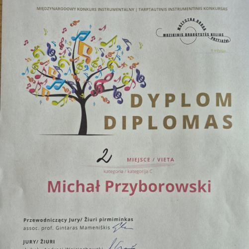 Dyplom z Międzynarodowego Konkursu Instrumentalnego w Puńsku. Dyplom przedstawia drzewo ozdobione różnego rodzaju kolorowymi nutami i kluczami muzycznymi. Z prawej złoty napis Dyplom w dwóch językach, Polskim i Litewskim. Na środku czerwonym kolorem 2 miejsce kategoria C i imię i nazwisko ucznia Michał Przyborowski. 