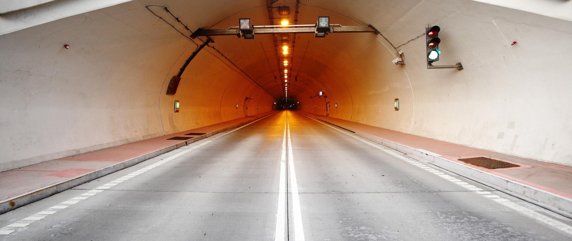 Zdjęcie przedstawia tunel Emilia zlokalizowany w miejscowości Laliki. Fotografia wykonana jest z perspektywy kierowcy wjeżdżającego do tunelu.