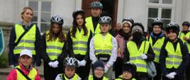 Minister Czarnek stoi w otoczeniu grupy młodzieży, wszyscy mają odblaskowe kamizelki i rowerowe kaski.