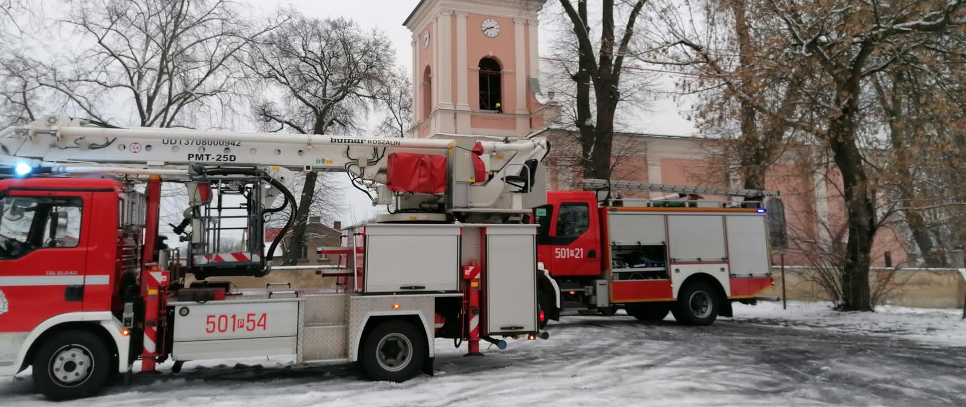 Zdjęcie przedstawia pojazdy pożarnicze przed kościołem w Kwilczu.
