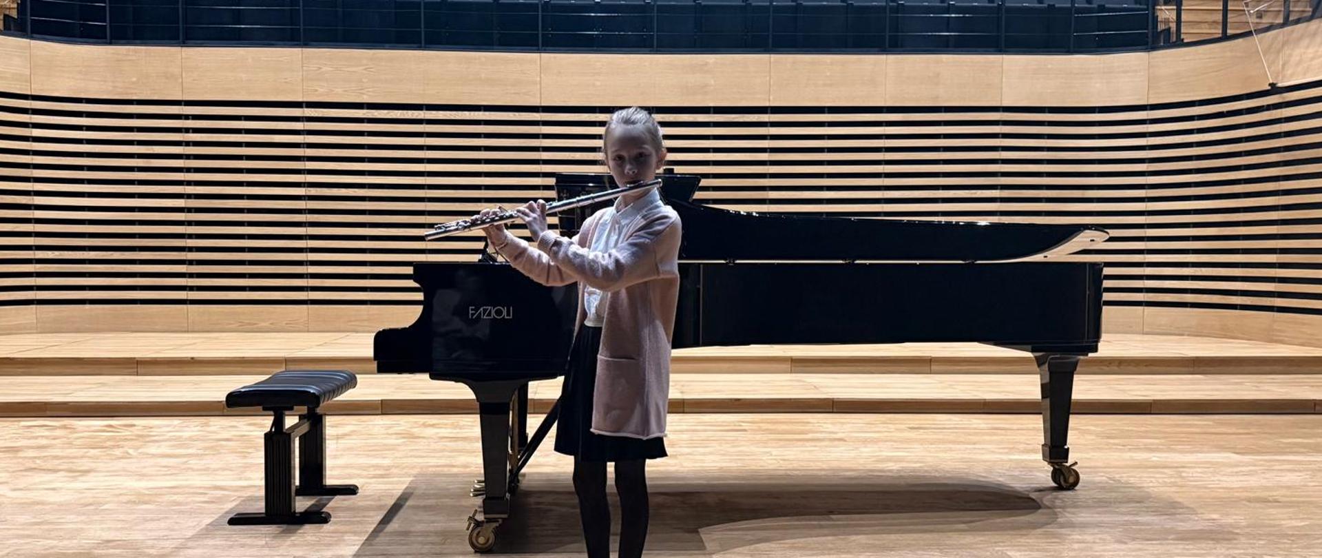 Dziewczynka gra na flecie.