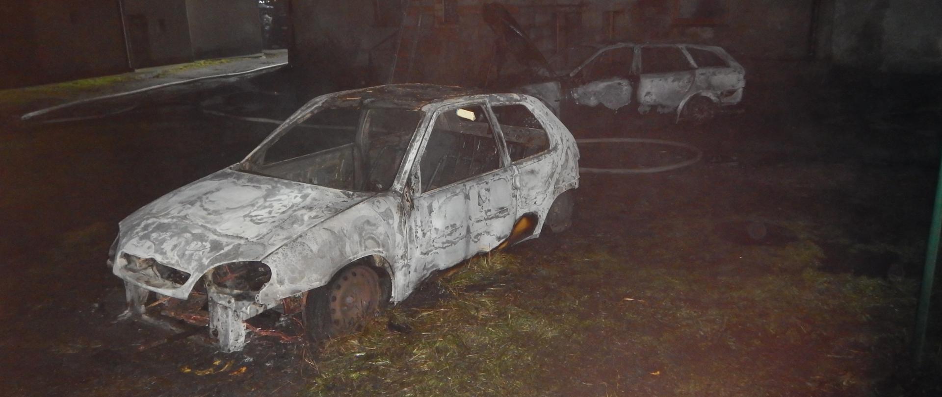 Zdjęcie przedstawia samochody osobowe po pożarze.