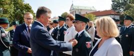 Wojewoda przypina medal funkcjonariuszowi Krajowej Administracji Skarbowej.