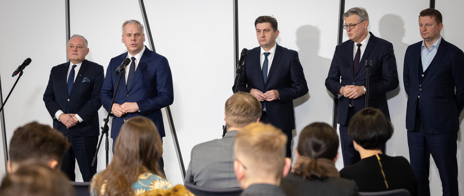 Wiceminister Karol Rabenda wraz z prezesami spółek PGE, PGG, i Węglokoks. Ujęcie zza słuchaczy. 