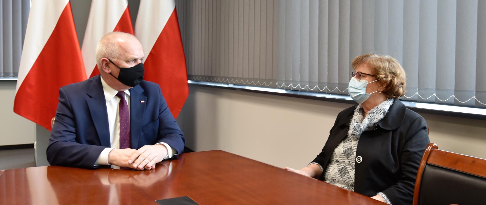 Wojewoda z poseł Płonką rozmawia przy stole w gabinecie 