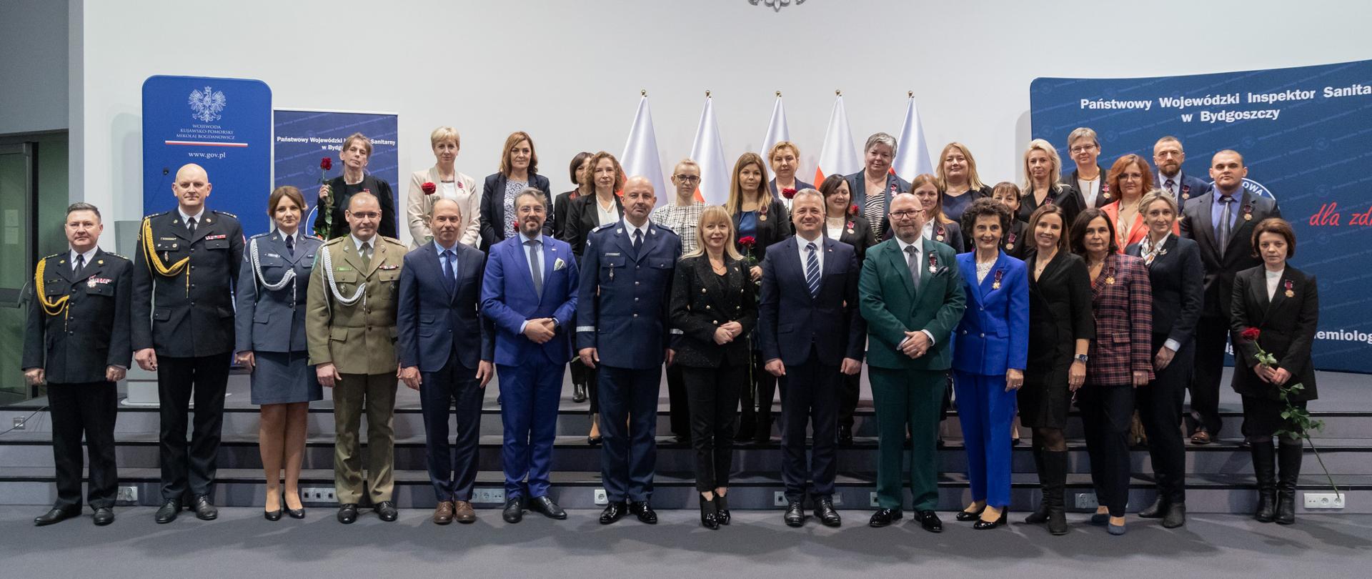 
Tłum ludzi stojący w sali konferencyjnej
