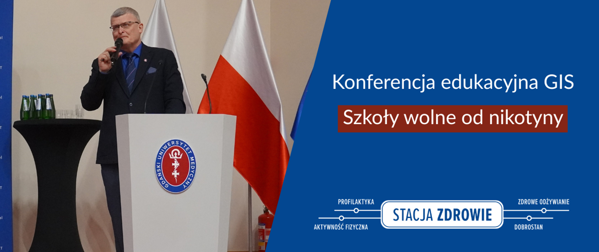 Po lewej stronie znajduje się mężczyzna w garniturze, przy mównicy, z mikrofonem w ręku. Po prawej znajduje się napis: Konferencja edukacyjna GIS, szkoły wolne od nikotyny