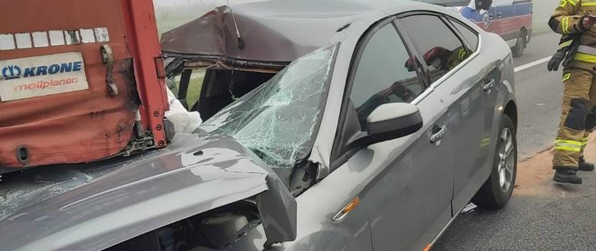 Zdjęcie przedstawia samochód osobowy, który wjechał w tył naczepy