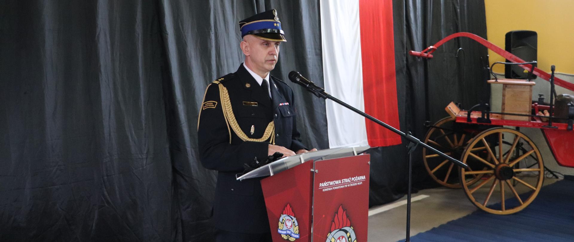 Komendant Powiatowy PSP w Środzie Wlkp. przemawia z mównicy podczas uroczystej zbiórki