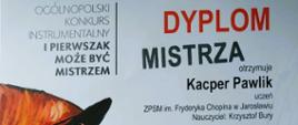 Wyraźne zbliżenie na oficjalny dokument. Jest to „Dyplom Mistrza” wydany w Warszawie w dniach 6-7 listopada 2025 roku podczas IX Ogólnopolskiego Konkursu Instrumentalnego „I Pierwszak Może Być Mistrzem”. Dyplom wystawiony jest dla Kacpra Pawlika, ucznia ZPSM im. Fryderyka Chopina w Jarosławiu z klasy nauczyciela Krzysztofa Burego. Na dokumencie widnieją podpisy jury (Łukasz Błaszczyk, Małgorzata Pernach, Łukasz Hodor) oraz artystyczna grafika dziecka z instrumentem.