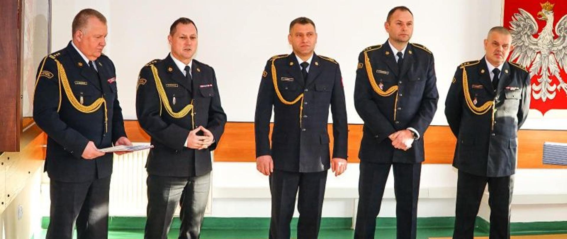 Zdjęcie przedstawia strażaków odchodzących na emeryturę oraz Komendanta. Jest to moment przemówienia Komendanta.