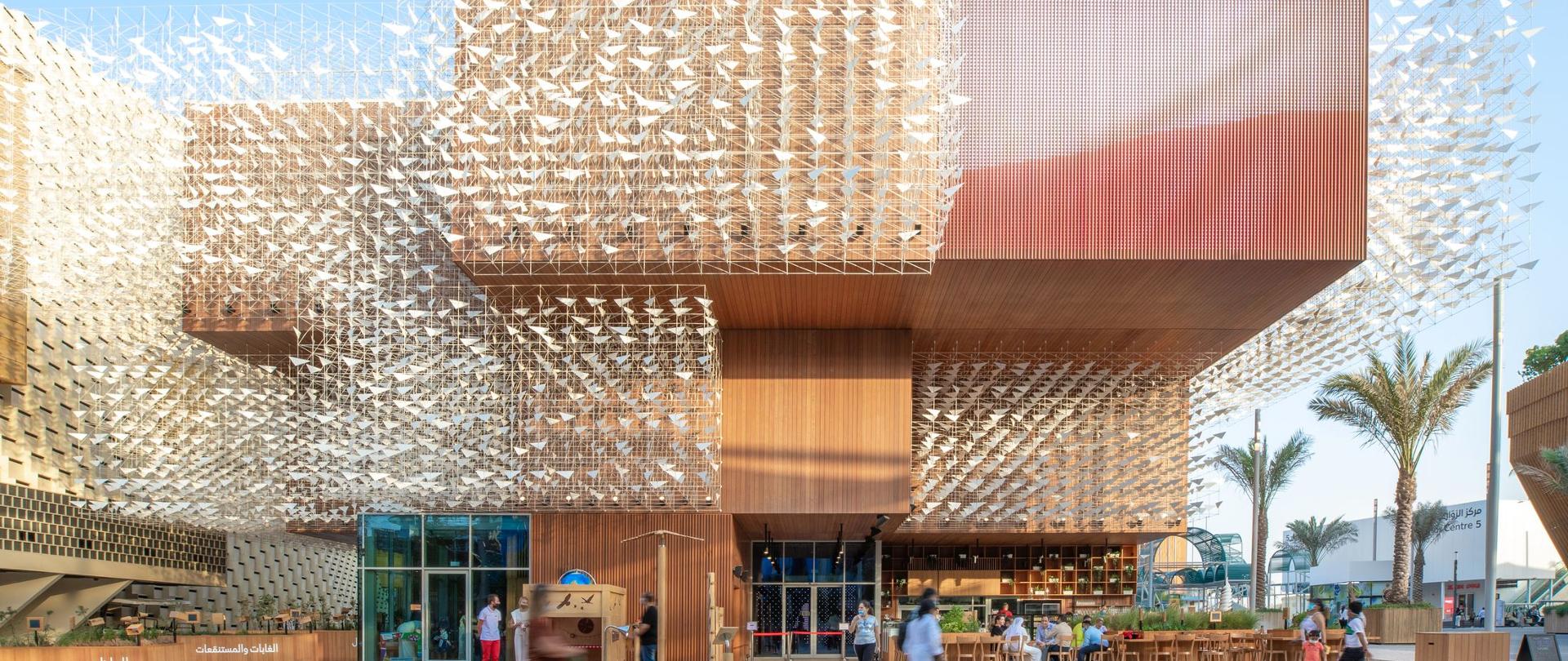Pawilon Polski na Expo 2020 Dubaj - widok na zewnątrz - pawilon zbudowany z drewna z metalowymi ażurowymi konstrukcjami zdobiącymi jego elewację