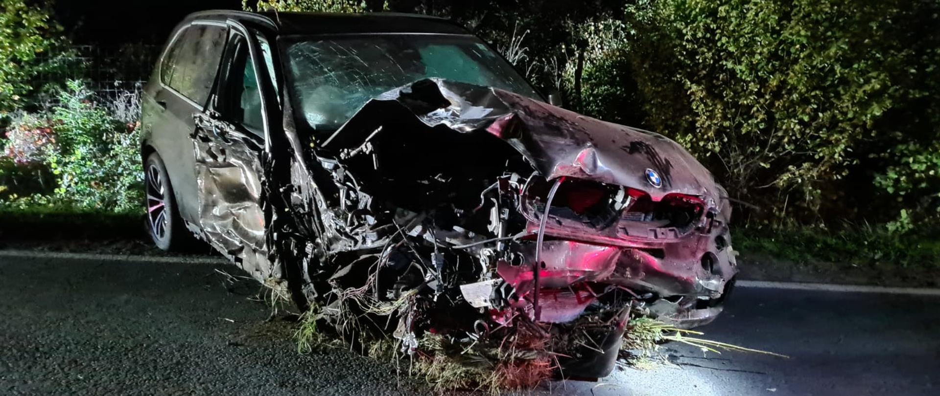 Uszkodzony prawy bok i przód pojazdu, jest na drodze, jest ciemno