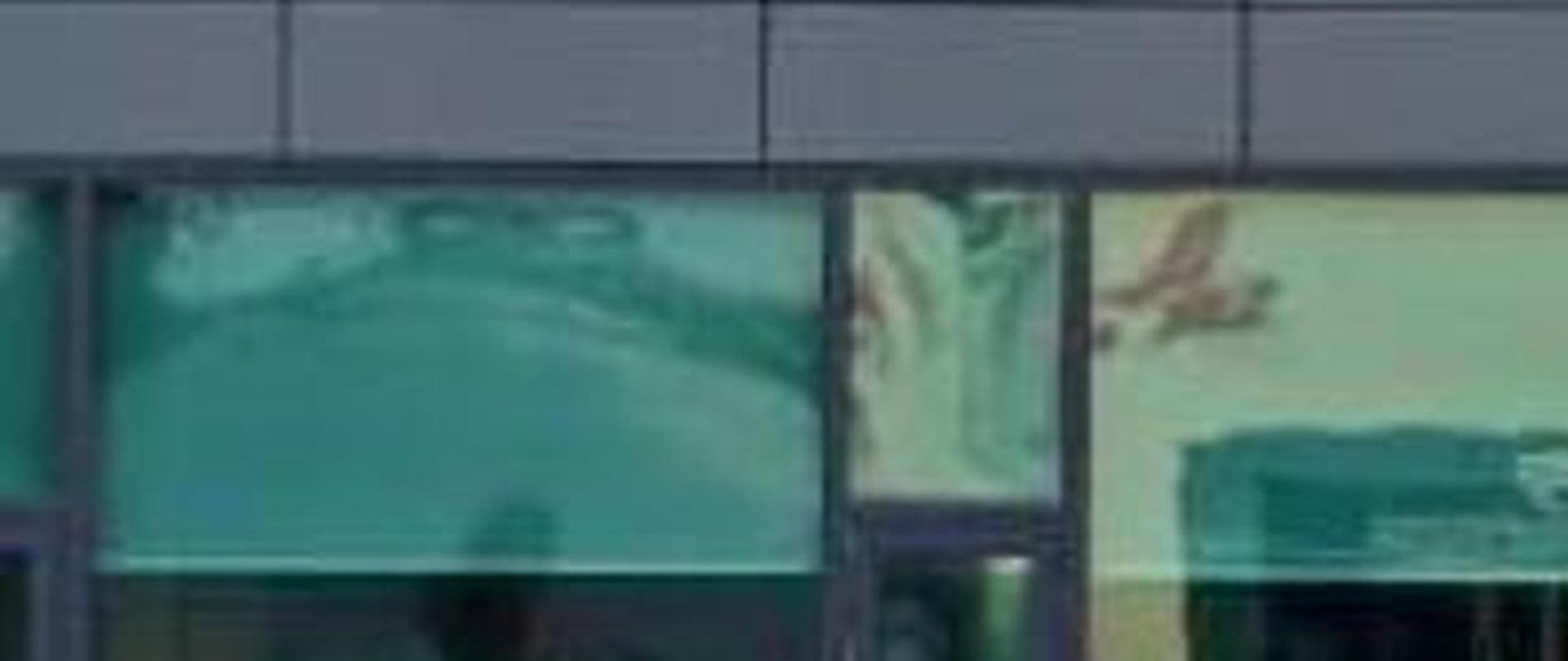 Wiceminister Grzegorz Piechowiak i prezes firmy SK Nexilis stoją przed budynkiem fabryki