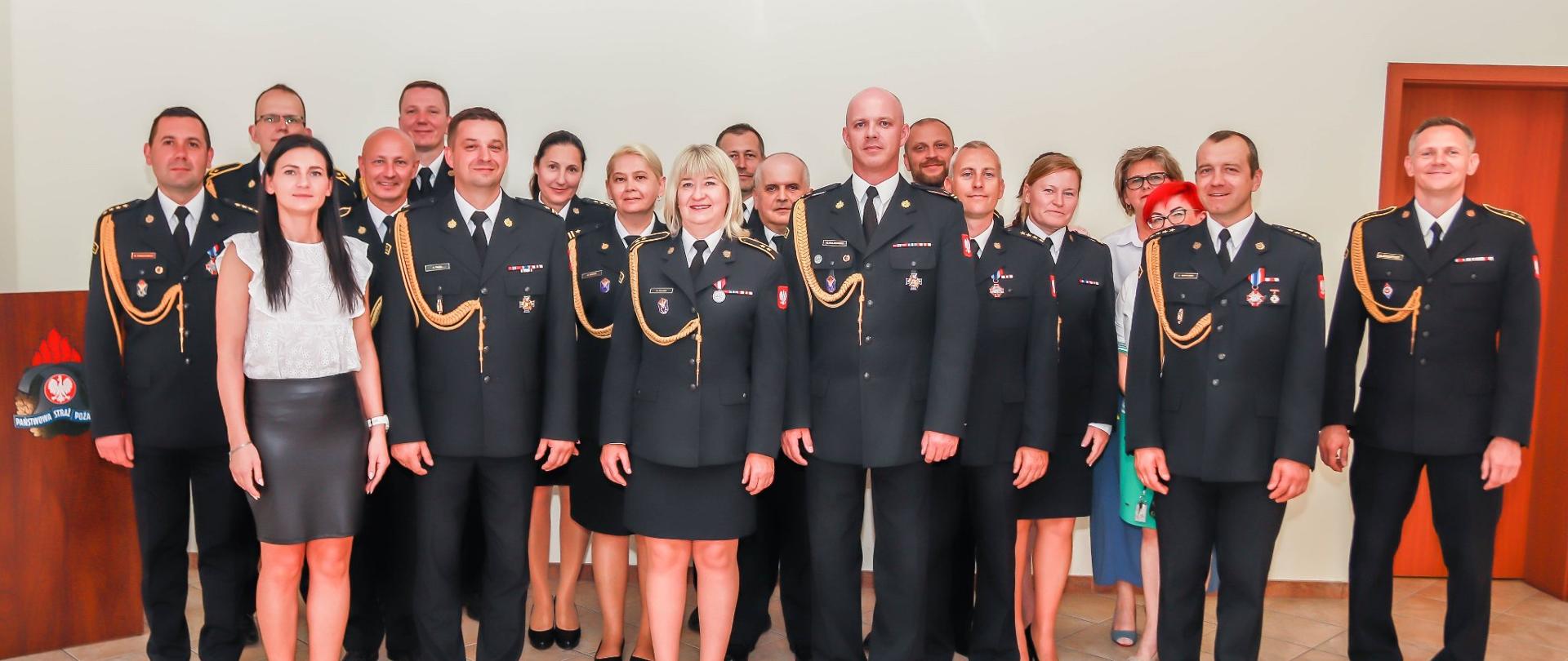 Zdjęcie grupowe funkcjonariuszy PSP, żegnających emerytkę.