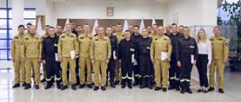 Grupowe zdjęcie funkcjonariuszy PSP będących uczestnikami szkolenia w towarzystwie Zastępcy Komendanta Centralnej Szkoły PSP wraz z przedstawicielami kadry wykładowczej CS PSP