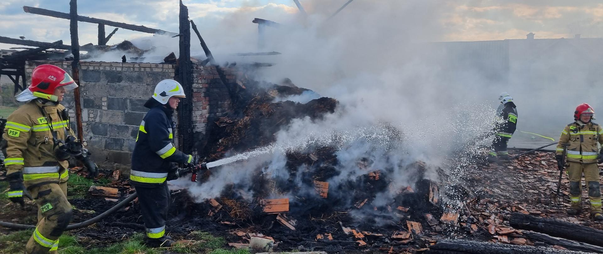 Strażacy dogaszają pogorzelisko po budynku gospodarczym