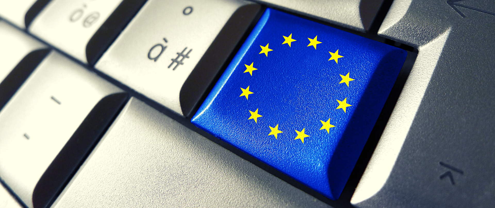 Bliskie ujęcie klawiatury komputerowej. Jeden z klawiszy to flaga Unii Europejskiej