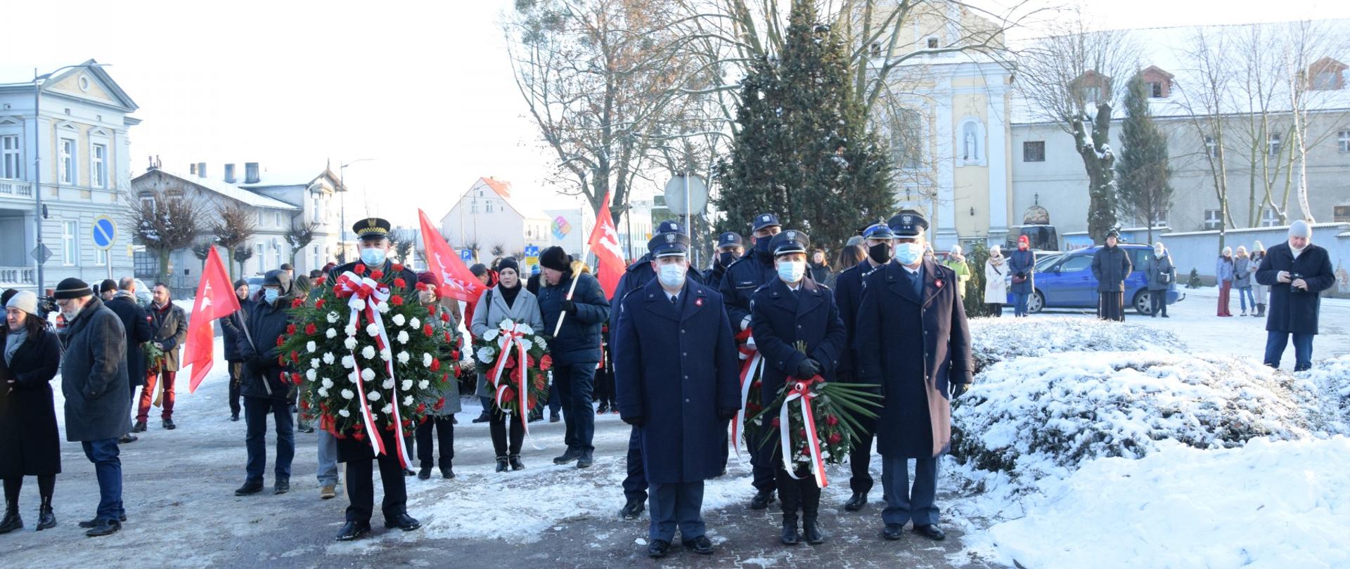 Widać przedstawicieli, którzy będą składać kwiaty pod pomnikiem