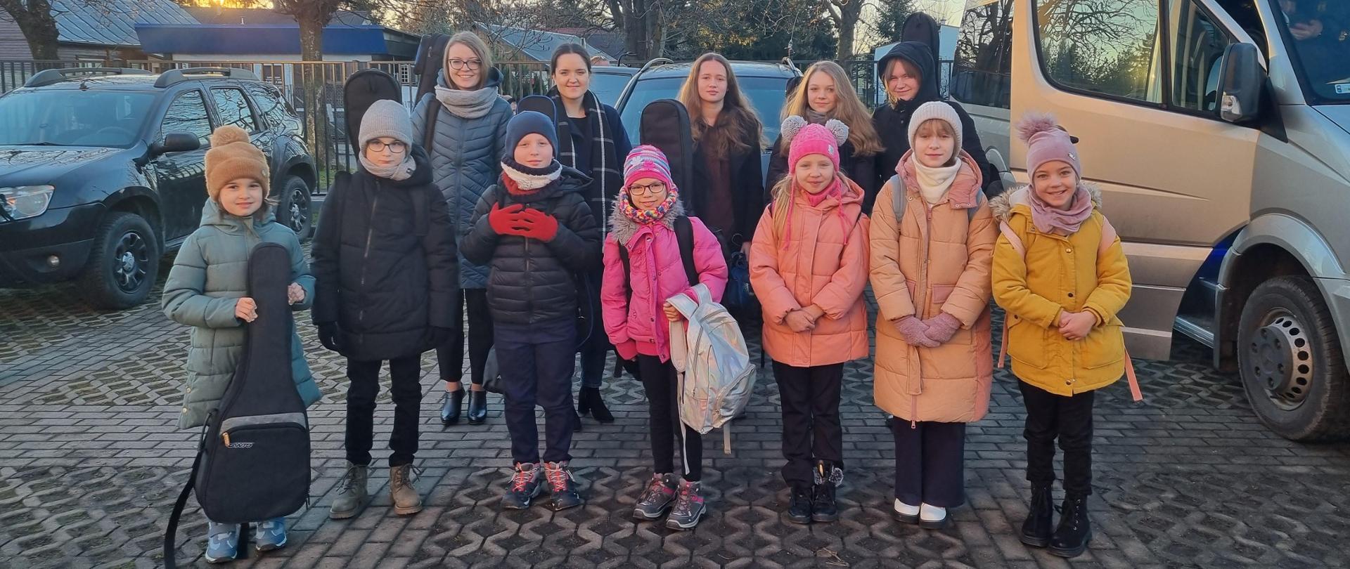 Zdjęcie uczniów, nauczycieli i rodziców na parkingu przed miejscem odbywania się konkursu