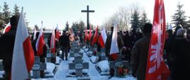 Widok na Kwaterę Powstańców Wielkopolskich na Cmentarzu Parafialnym w Środzie Wielkopolskim podczas uroczystości obchodów Narodowego Dnia Zwycięskiego Powstania Wielkopolskiego. Liczne delegacje w tym służb mundurowych z Flagami Narodowymi i Powstańczymi