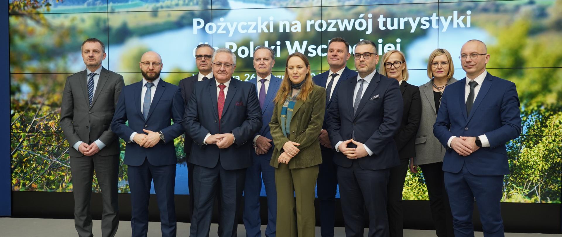 Grupa osób pozuje na scenie