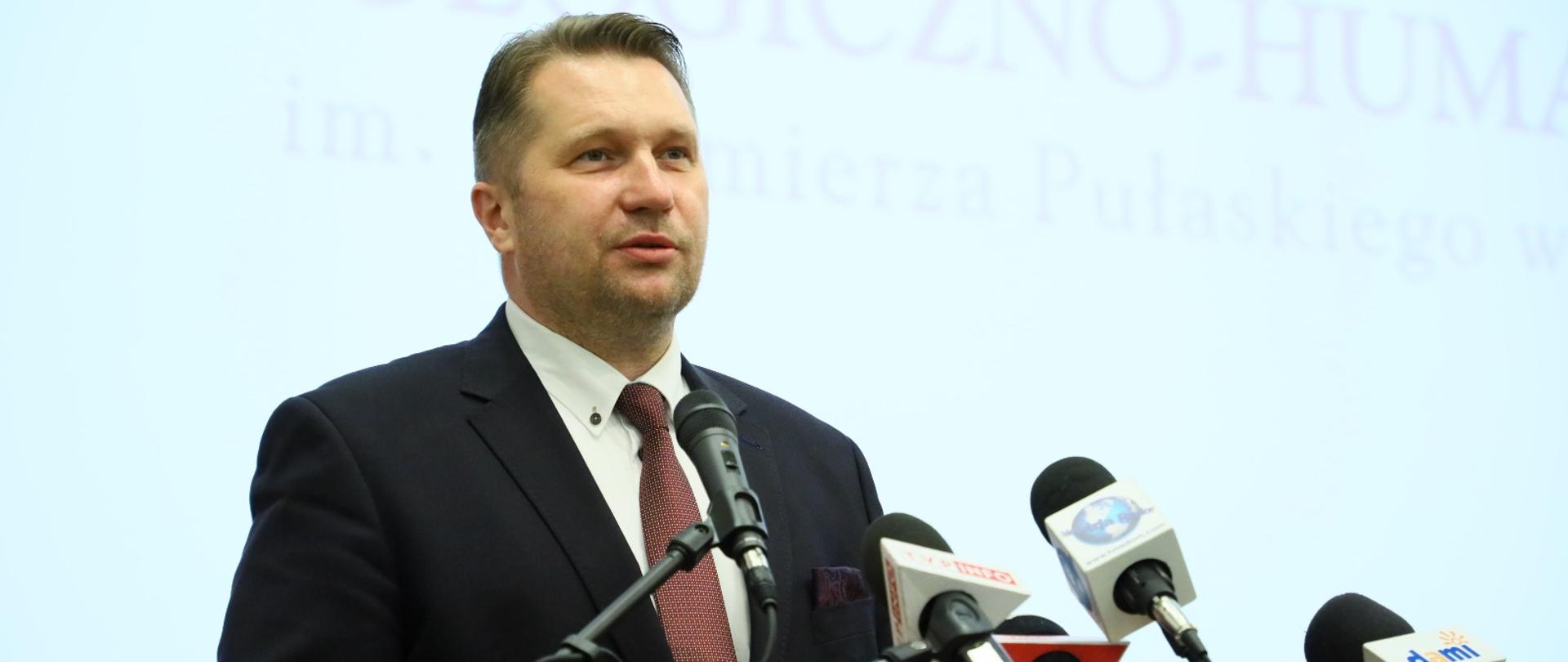 Inauguracja roku akademickiego 2021/2022 na Uniwersytecie Technologiczno-Humanistycznym w Radomiu z udziałem Ministra Edukacji i Nauki. minister przemawia do mikrofonów, w tle napis z nazwą uniwersytetu. 