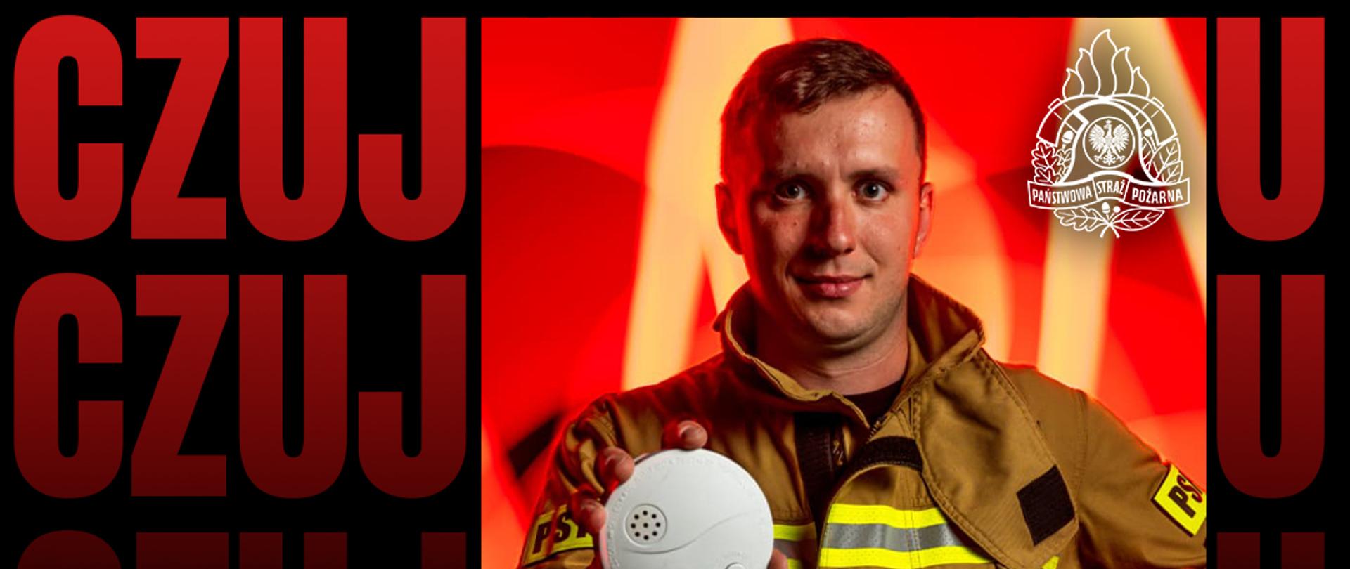 Zdjęcie przedstawia strażaka trzymające w dłonic czujkę dymu.