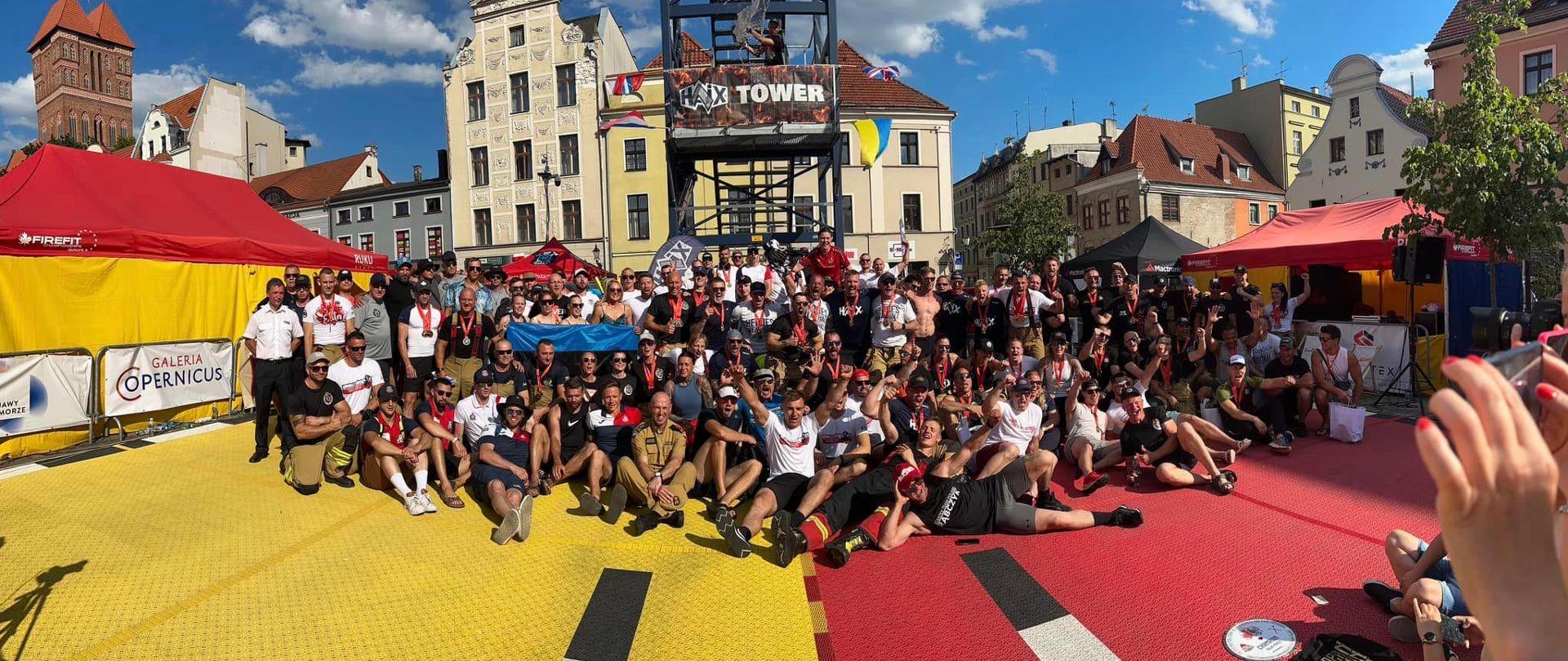 Zdjęcie grupowe uczestników zawodów na tle wieży.