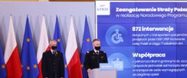Komendant Główny Państwowej Straży Pożarnej nadbryg. Andrzej Bartkowiak oraz druh Andrzej Matczak podczas konferencji prasowej. Z tyłu biało-czerwone flagi oraz flagi Unii Europejskiej oraz ekran prezentacyjny
