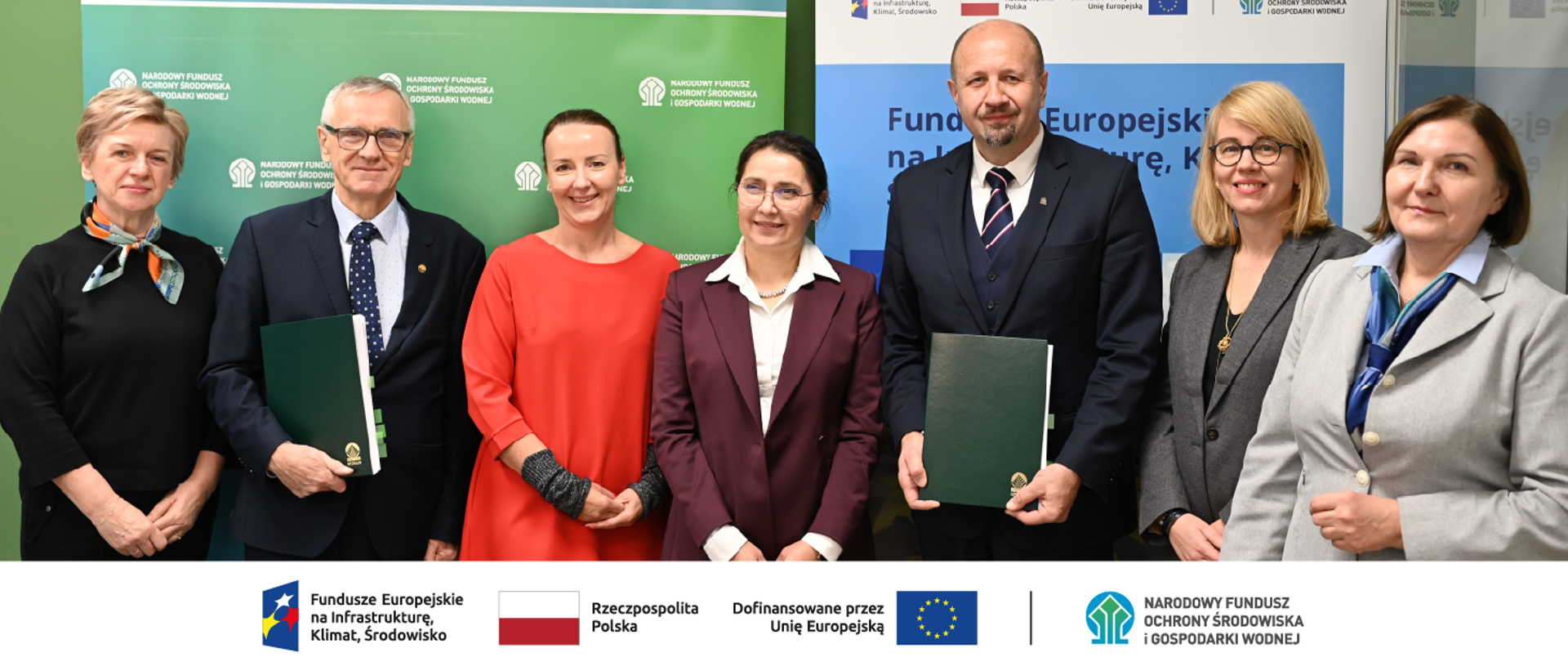 Zdjęcie przedstawia grupę stojących osób 5 kobiet i 2 mężczyzn. W stopce zdjęcia ciąg logotypów: Fundusze Europejskie na Infrastrukturę, Klimat, Środowisko, flaga Rzeczypospolita Polska, flaga UE Dofinansowane przez UE, NFOŚiGW.