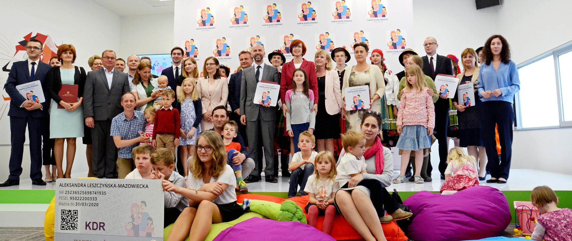 Podpisanie umów z nowymi partnerami Karty Dużej Rodziny. Wspólne zdjęcie uczestników wydarzenia z minister rodziny Elżbietą Rafalską.