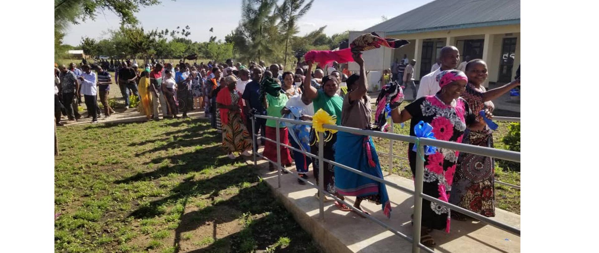 Czarnoskóre kobiety w tradycyjnych strojach tańczą na świeżym powietrzu.