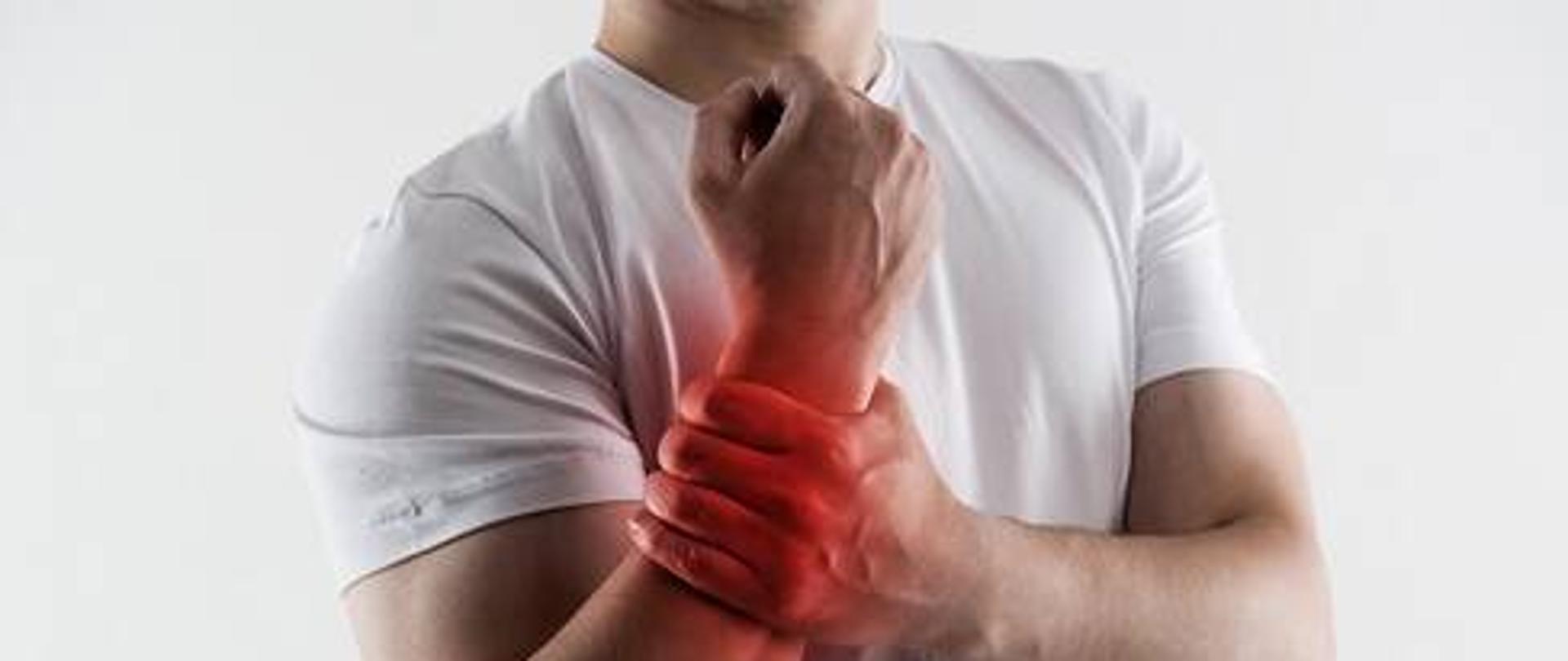 człowiek trzymający się za nadgarstek