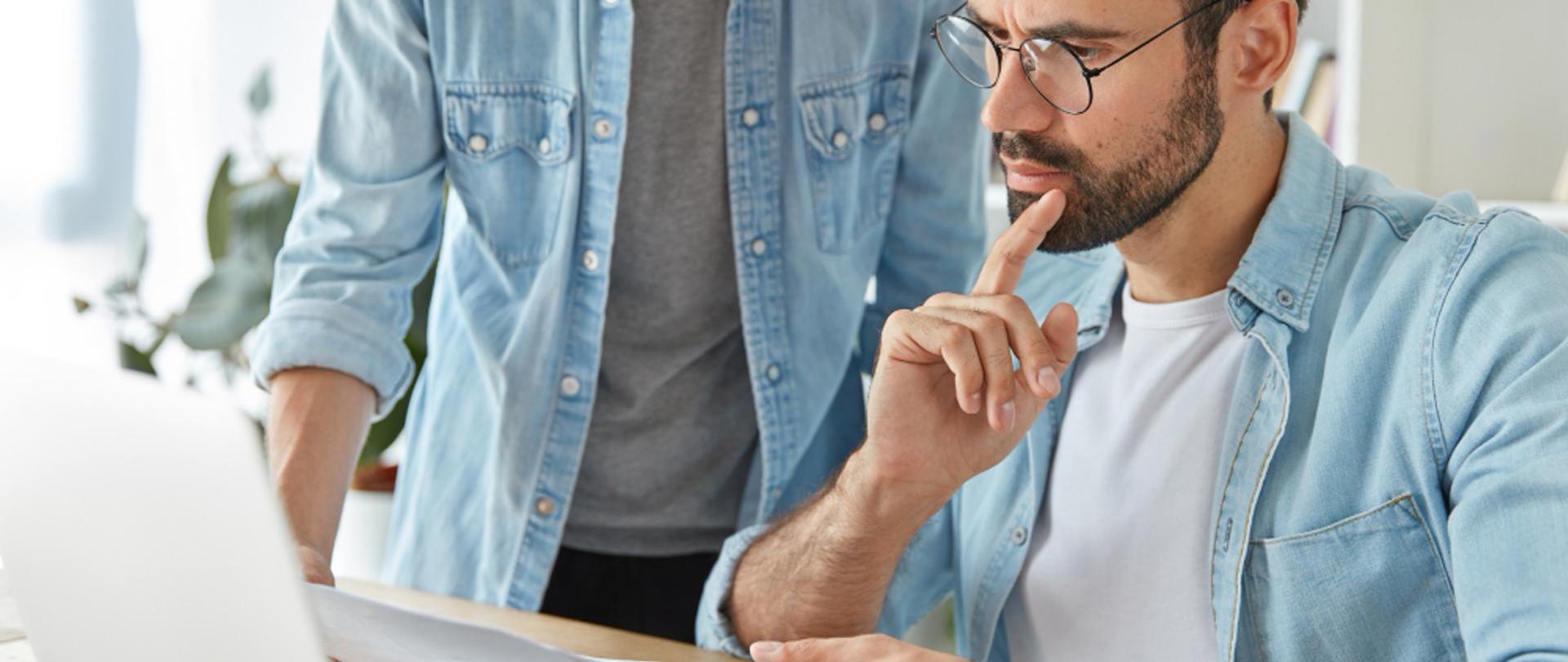 Mężczyzna przy laptopie wypełniający dokumenty
