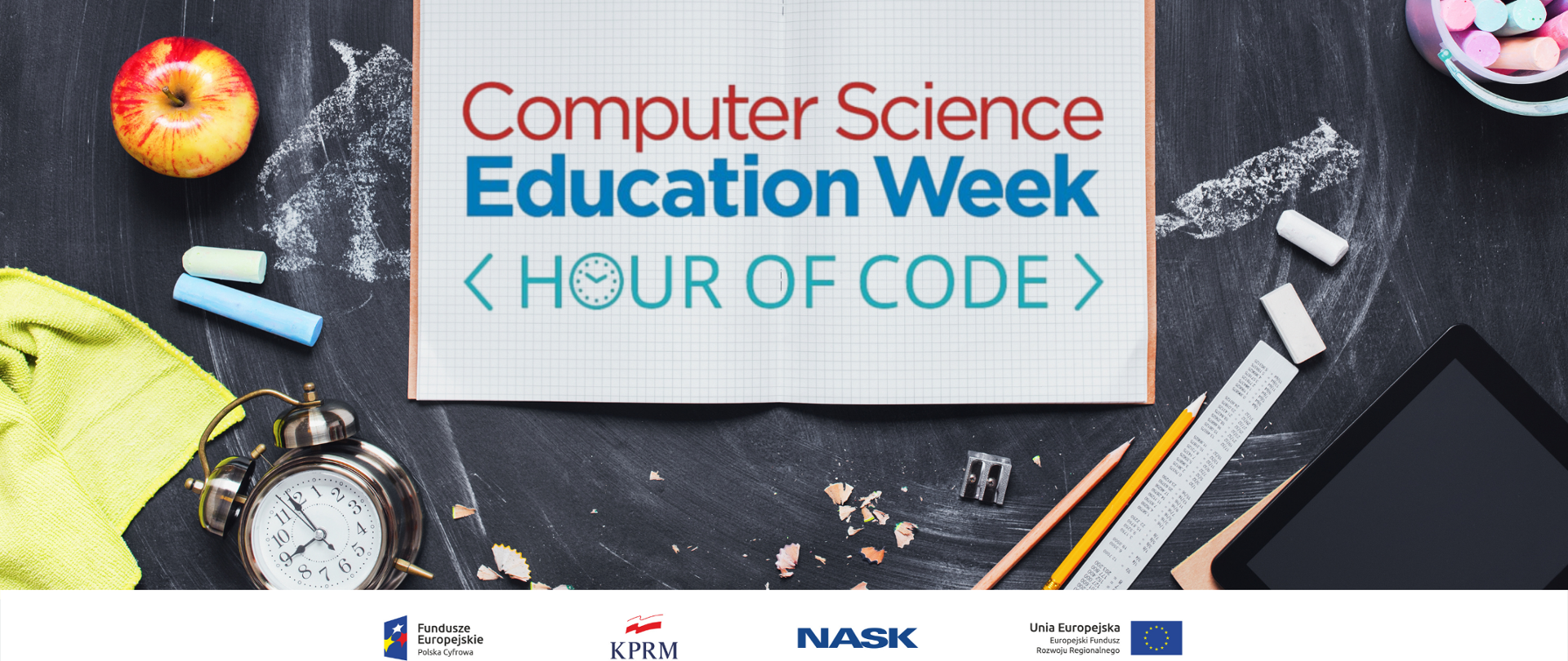 Zdjęcie - rozłożony zeszyt na tle szkolnej tablicy. W zeszycie tekst: Computer Science Education Week Hours od code. Wokół zeszyty leżą m.in. kreda, ołówki, tablet, temperówka, budzik i jabłko.