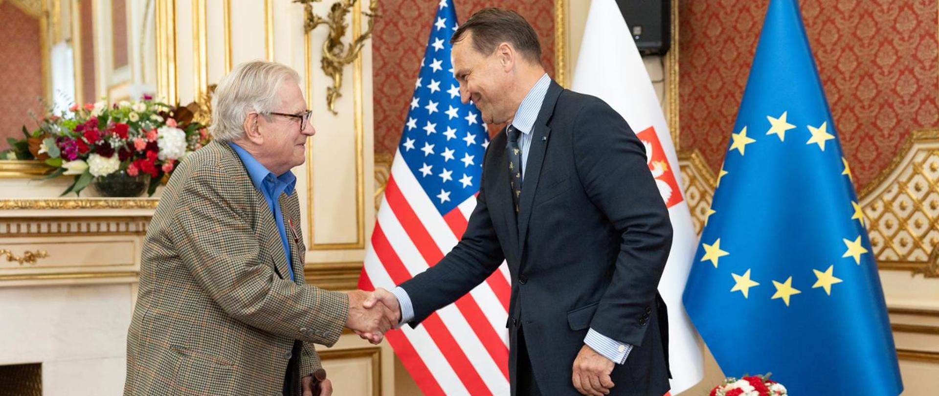 Na zdjęciu są minister Radosław Sikorski i Wacław Godziemba-Maliszewski, który przekazał "Archiwum Katyńskie" do Archiwum Akt Nowych w Warszawie. W tle są flagi: Polski, USA i Unii Europejskiej.