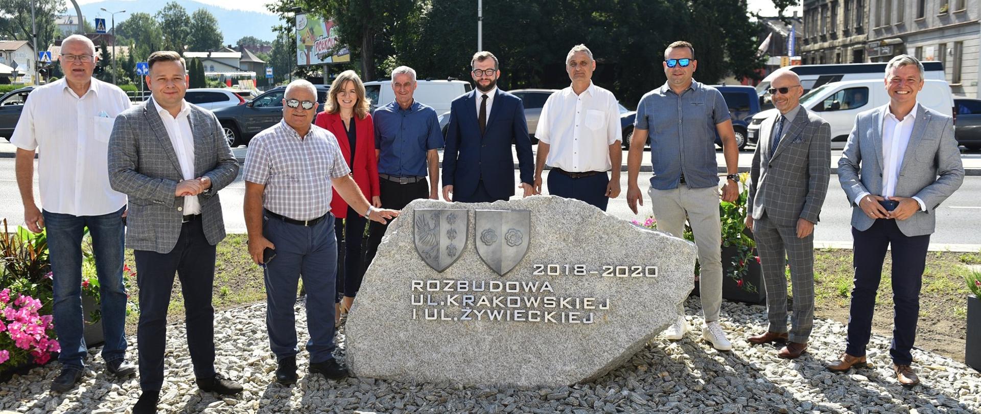 Na zdjęciu grupa osób wśród nich minister Puda, stoi przy kamieniu z napisem "2018-2020" Rozbudowa ul. Krakowskie i ul. Żywieckiej"