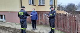 Dystrybucja ulotek. Strażacy wręczają ulotki na temat szczepień mieszkaniom powiatu.