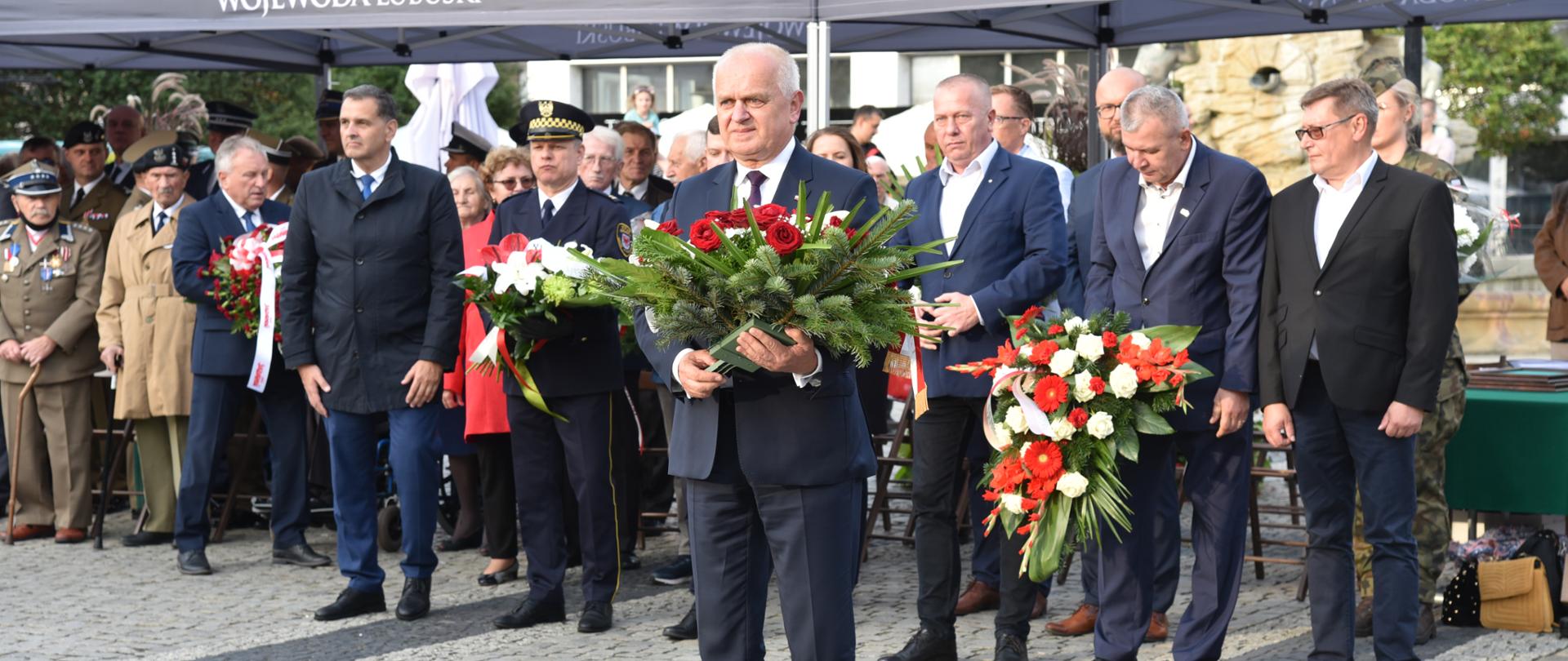 Wojewoda stoi z wieńcem 