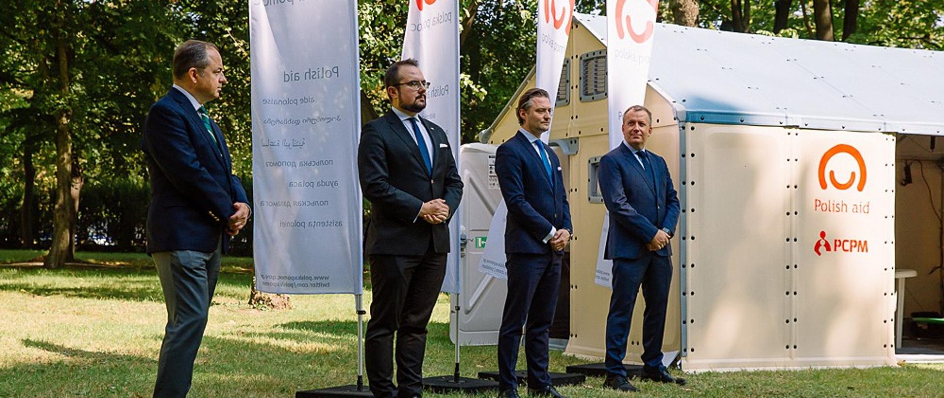 Ministrowie na tle domu modułowego.