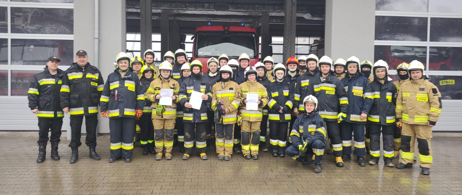Na zdjęciu strażacy ratownicy na zdjęciu grupowym wraz z otrzymanymi zaświadczeniami o pozytywnym zdaniu egzaminu