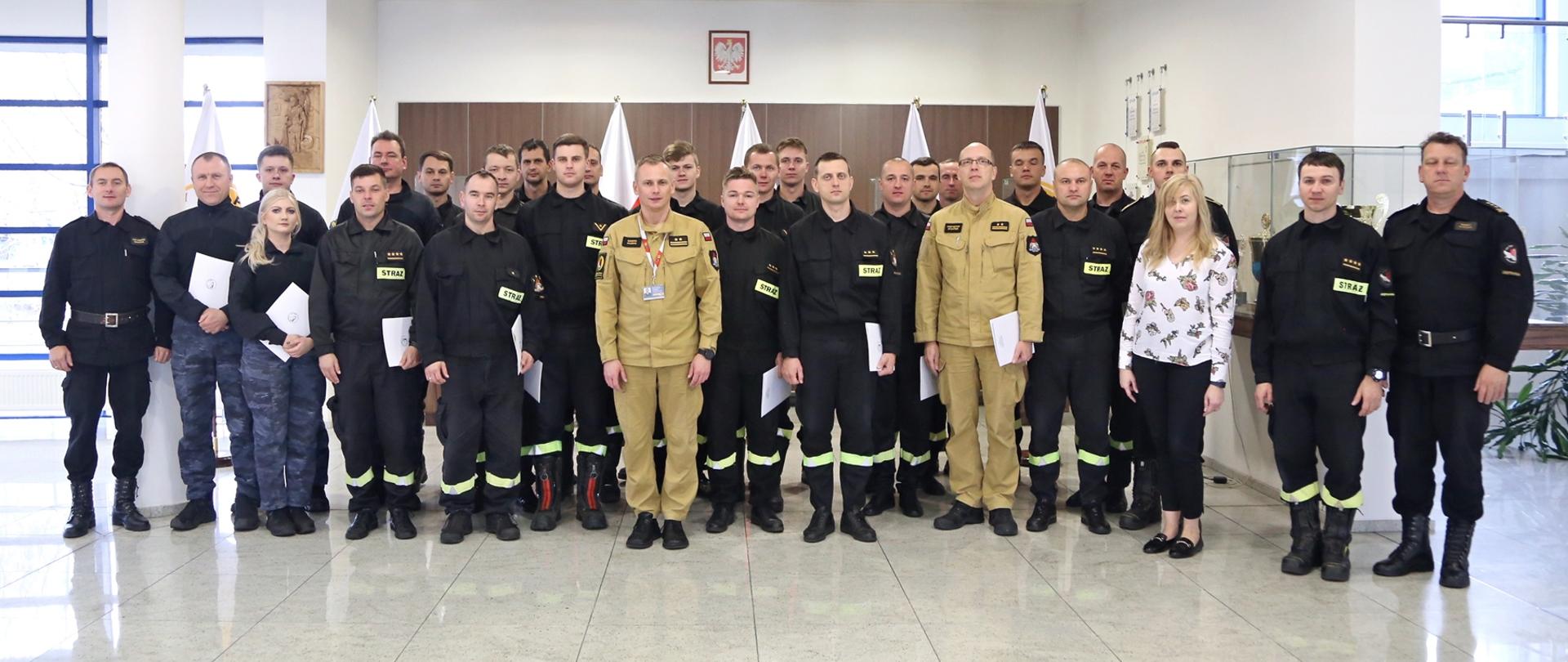Grupowe zdjęcie uczestników szkolenia (23 osoby) w towarzystwie Zastępcy Komendanta CS PSP, kobiety oraz czterech funkcjonariuszy CS PSP
