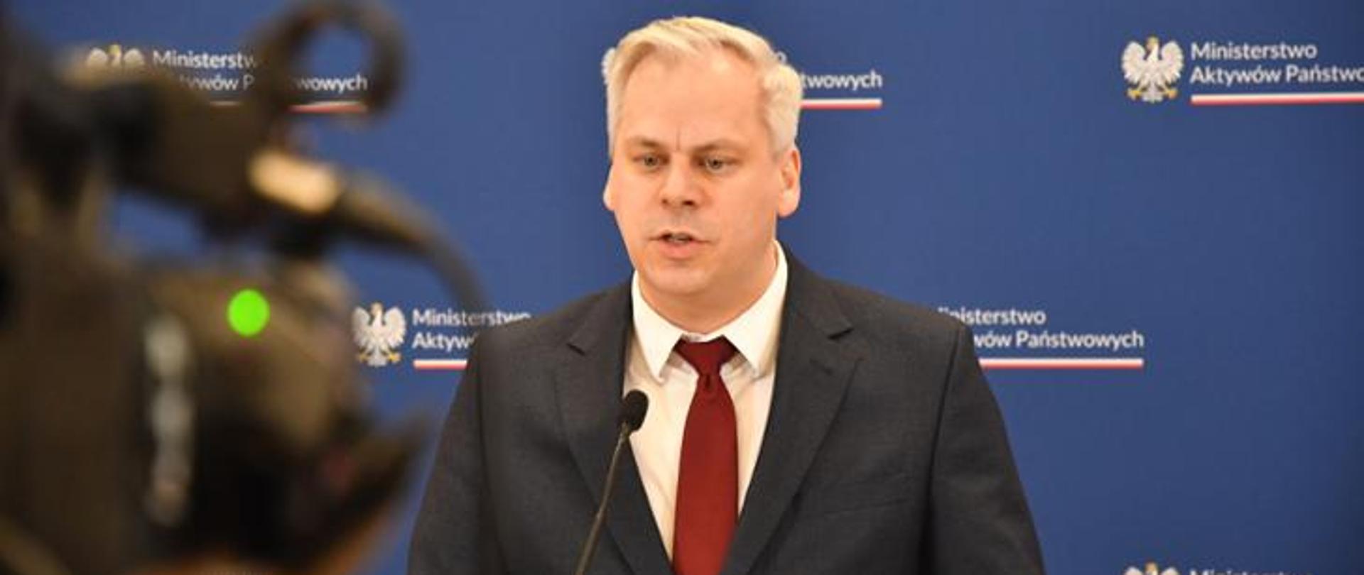 Jeden mężczyzna stojący przed mikrofonem i wypowiadający się