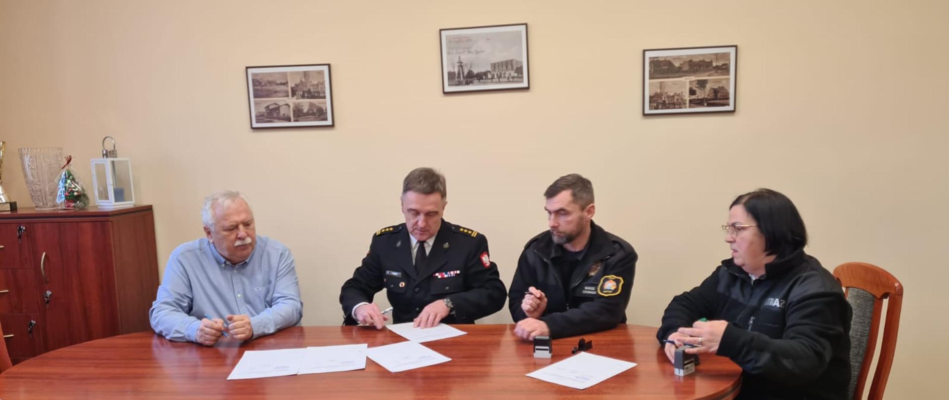 Podpisanie porozumienia przy stole, cztery osoby