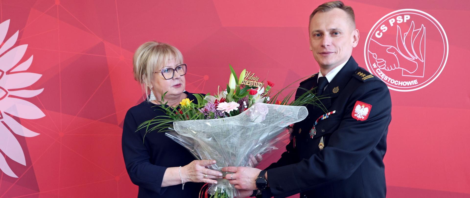 Odchodząca na emeryturę Pani Irena otrzymuje od p.o. Komendanta Centralnej Szkoły PSP okolicznościowy bukiet kwiatów